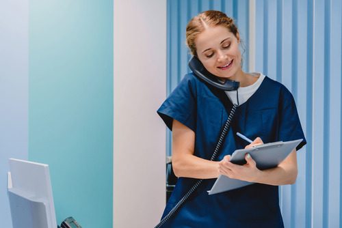 A medical office assistant takes a call from a patient