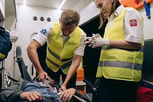 Paramedics provide aid to a patient in cardiac arrest