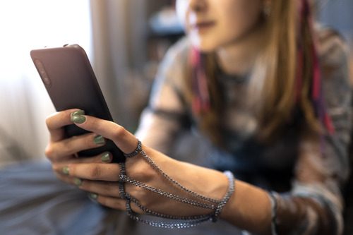 Girl busy using her smartphone and learning Mobile App Development Courses