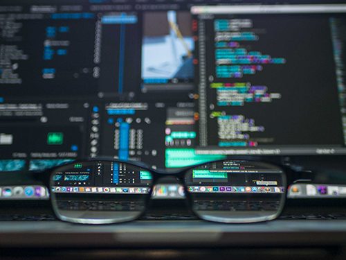 A master coder admires the final revision of her program through the lens of her glassese