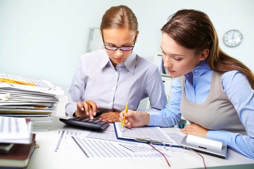 Two employees working on accounting tasks