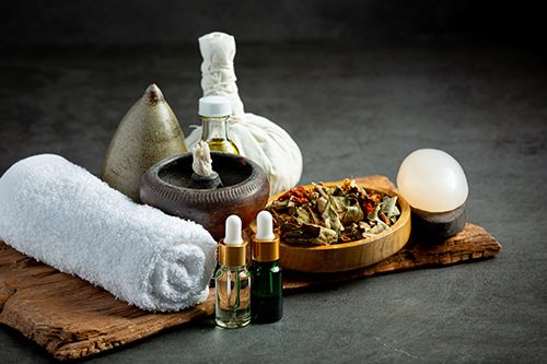 Massage supplies including towels, stones, scents, and oils