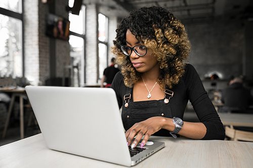 A computer programmer polishes up her latest code in an open concept office