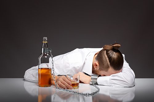 A tired young businessman drowns his sorrows after realizing he drunkenly asked his barber for a manbun