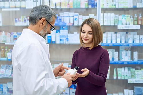 A friendly Pharmacist assists a customer with helpful advice