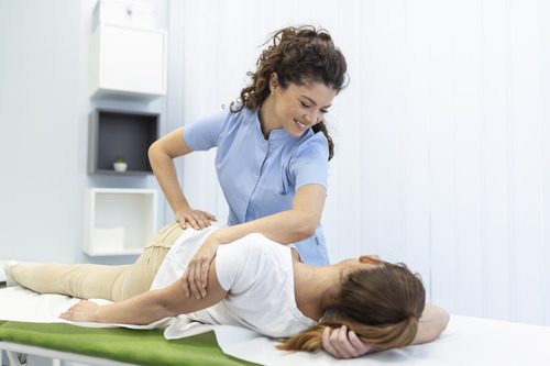 A female physiotherapist healing her patient