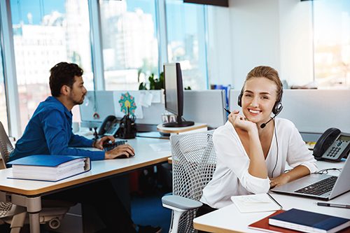 Help Desk Analyst assisting a customer using a headset and laptop