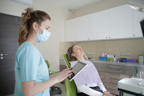 A Dental Office Assistant takes down patient information for the Dentist