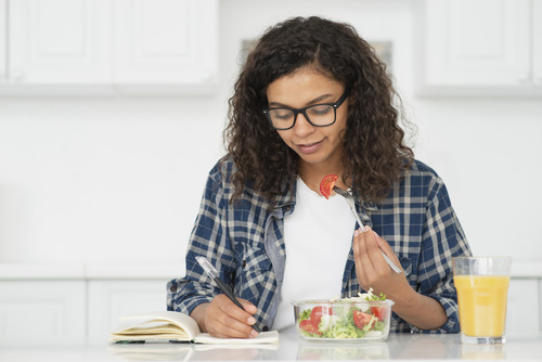 College student having fruits and juice while studying 