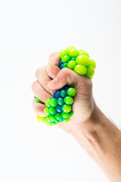 Male hand holding a stress ball and relieving his stress 