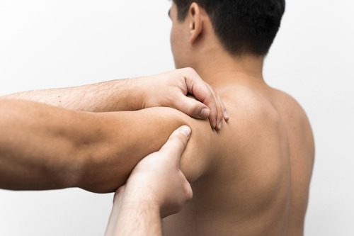 Man getting shoulder massage from physiotherapist after sports injury