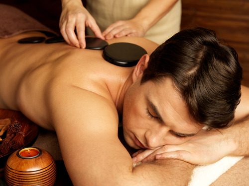 Handsome man having a stone massage at a spa as part of healthy lifestyle